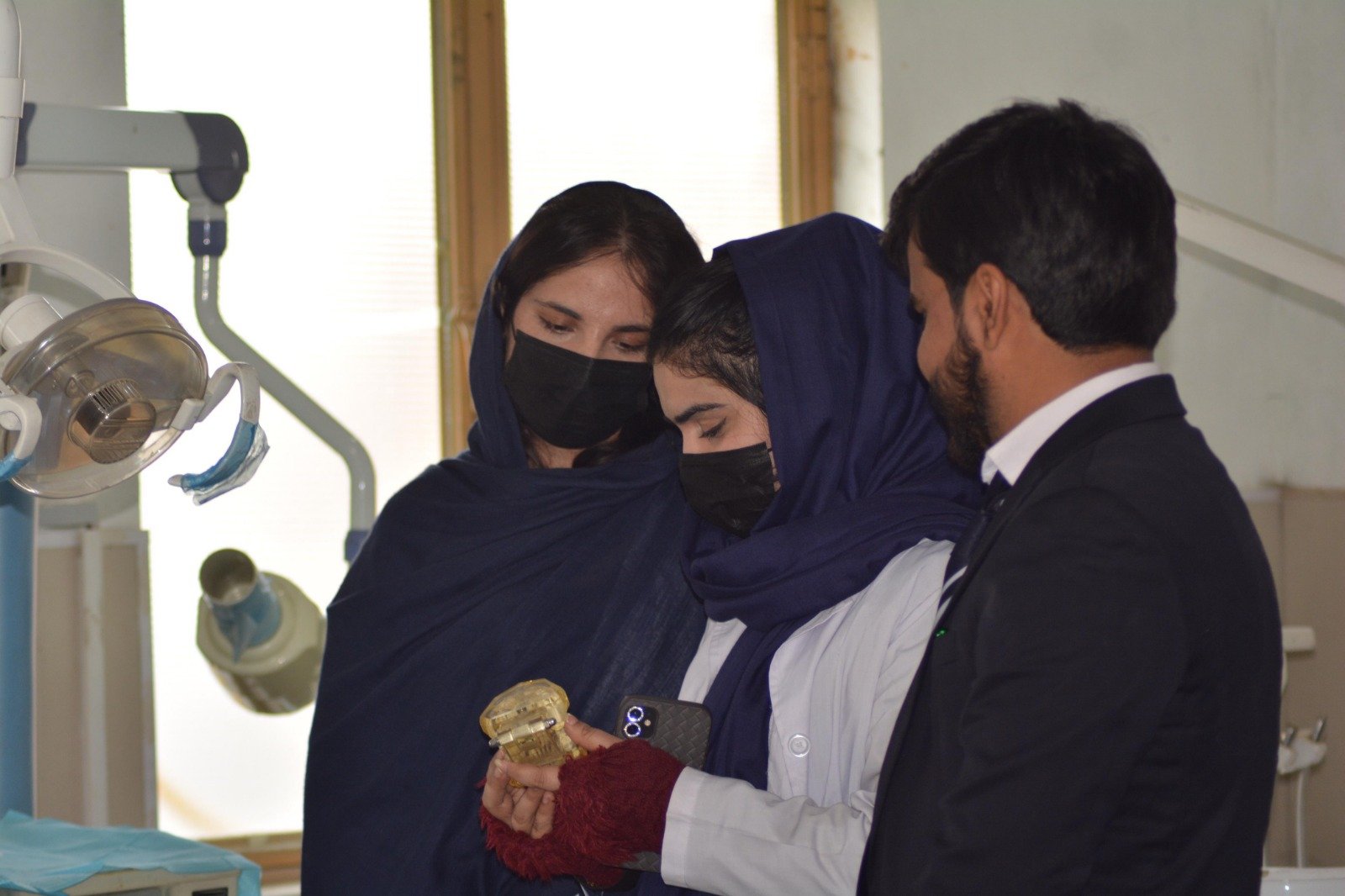 Students examining a medical training model with an instructor